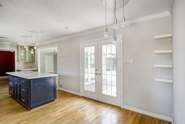 kitchen featuring blue cabinets, french doors, light wood-type flooring, baseboards, and decorative light fixtures