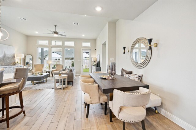 dining room with light wood-style flooring, visible vents, baseboards, and ceiling fan