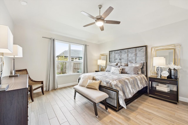 bedroom with light wood-style flooring, baseboards, and ceiling fan