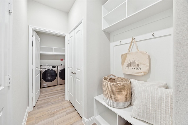 washroom with independent washer and dryer, wood finished floors, baseboards, and laundry area