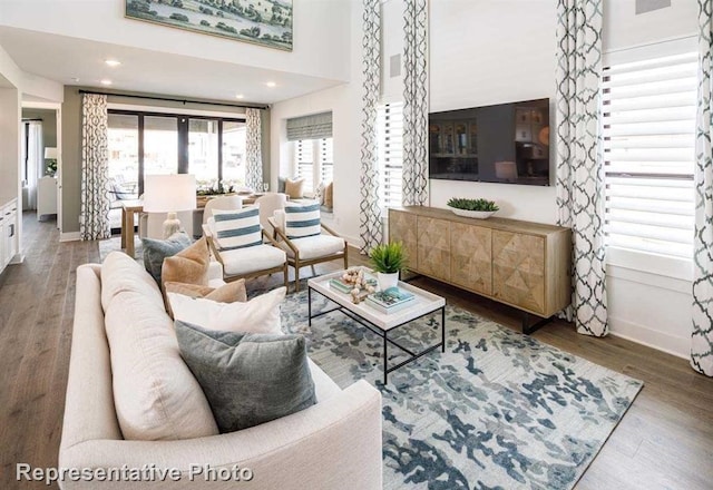 living room with wood finished floors, baseboards, and recessed lighting