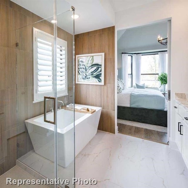 full bath featuring marble finish floor, a shower with door, wooden walls, connected bathroom, and a freestanding tub