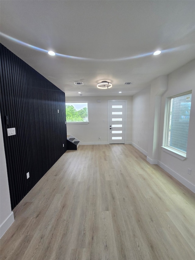 empty room featuring recessed lighting, light wood finished floors, and baseboards