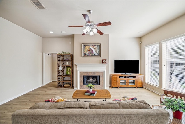 6315 Teal Mist Ln, Fulshear, TX 77441 - living room with ceiling fan, a fireplace, baseboards, wood finished floors, and visible vents