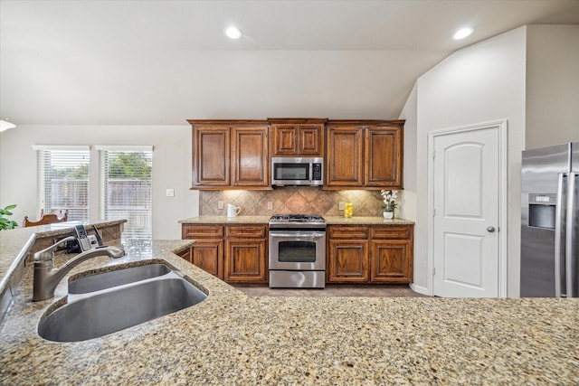 6315 Teal Mist Ln, Fulshear, TX 77441 - kitchen featuring appliances with stainless steel finishes, tasteful backsplash, vaulted ceiling, brown cabinets, and a sink