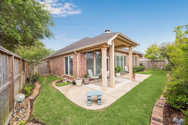 6315 Teal Mist Ln, Fulshear, TX 77441 - back of property featuring a patio, a fenced backyard, roof with shingles, brick siding, and a lawn
