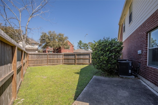 view of yard with central air condition unit, a fenced backyard, and a patio
