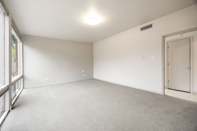 unfurnished room featuring visible vents, baseboards, and light colored carpet
