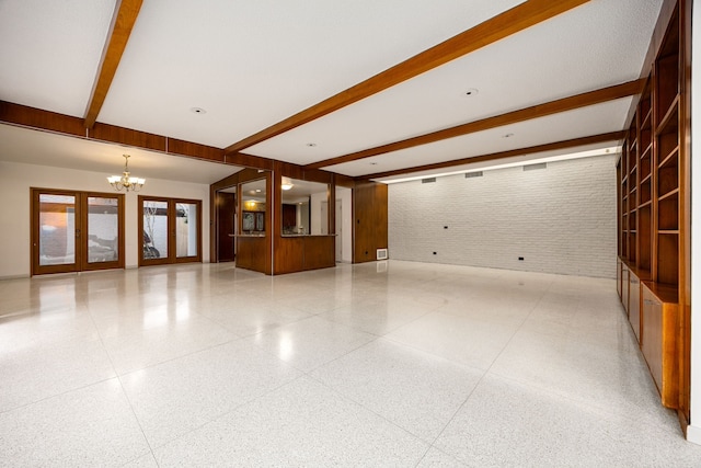 3622 N Braeswood Blvd, Houston, TX 77025 - unfurnished living room featuring dark speckled floor, a chandelier, beamed ceiling, and brick wall