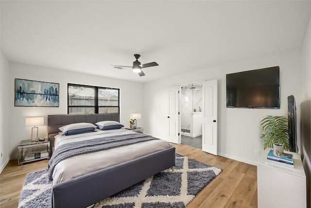 bedroom featuring baseboards, light wood-style floors, a ceiling fan, and connected bathroom