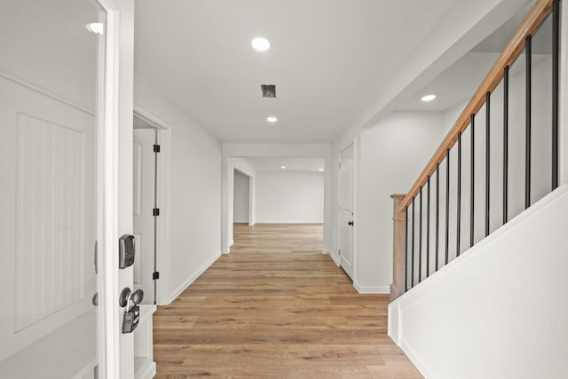 corridor with recessed lighting, light wood-style floors, stairway, and baseboards