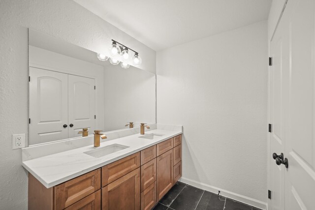 full bathroom featuring tile patterned flooring, double vanity, and baseboards
