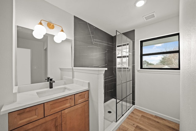 full bath with wood finished floors, walk in shower, vanity, and baseboards