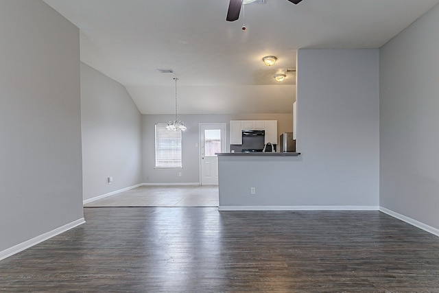 6626 Rusty Ridge Ln, Katy, TX 77449 - unfurnished living room with ceiling fan with notable chandelier, baseboards, wood finished floors, and visible vents
