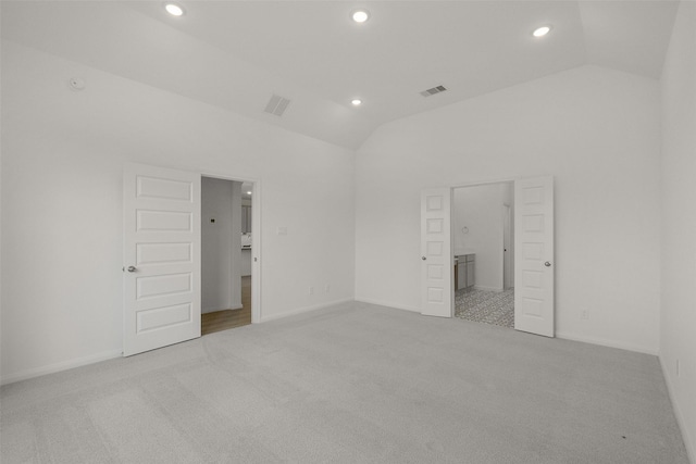 unfurnished bedroom with lofted ceiling, carpet floors, visible vents, and recessed lighting