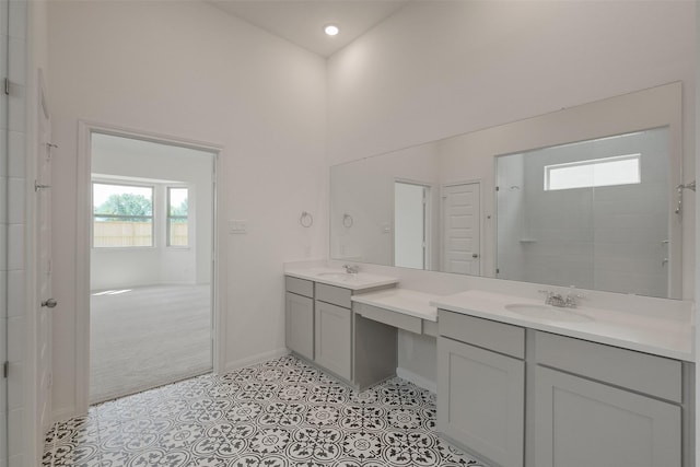 bathroom featuring recessed lighting, a towering ceiling, vanity, baseboards, and tiled shower