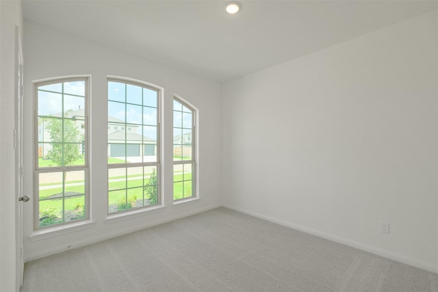 spare room featuring recessed lighting, baseboards, and light colored carpet
