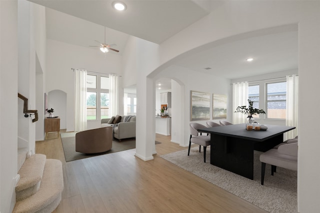 dining room with recessed lighting, stairway, a ceiling fan, arched walkways, and light wood-style floors