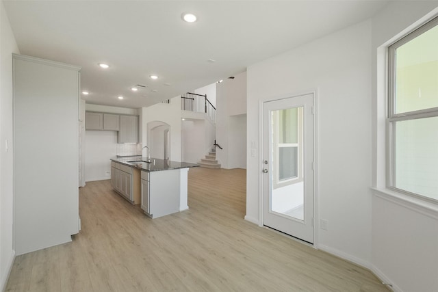 kitchen featuring recessed lighting, light wood-style flooring, a healthy amount of sunlight, and a sink