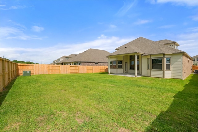 back of property with a fenced backyard, a patio area, and a lawn