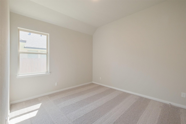 unfurnished room with baseboards, lofted ceiling, and carpet flooring