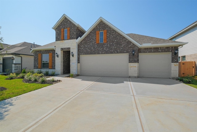 view of front of home with roof with shingles, driveway, stone siding, brick siding, and an attached garage