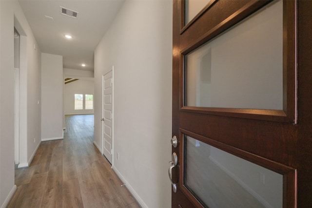 hall with recessed lighting, wood finished floors, visible vents, and baseboards