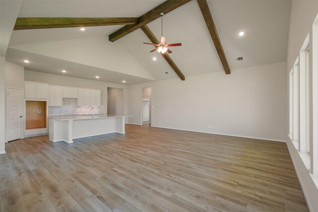 unfurnished living room featuring recessed lighting, visible vents, light wood-type flooring, beam ceiling, and ceiling fan