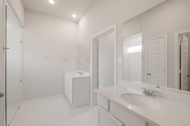 bathroom featuring two vanities, tile patterned floors, baseboards, and a sink