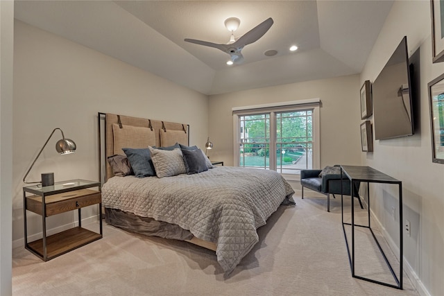 bedroom featuring a raised ceiling, baseboards, a ceiling fan, and light colored carpet