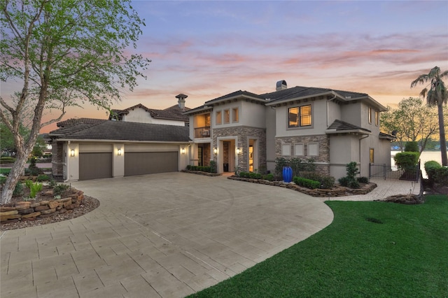 view of front of home featuring fence, stucco siding, an attached garage, driveway, and stone siding