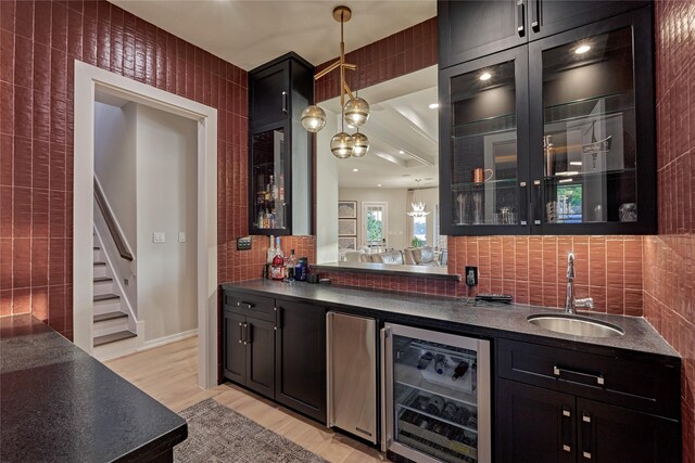 bar featuring a sink, beverage cooler, tasteful backsplash, and wet bar