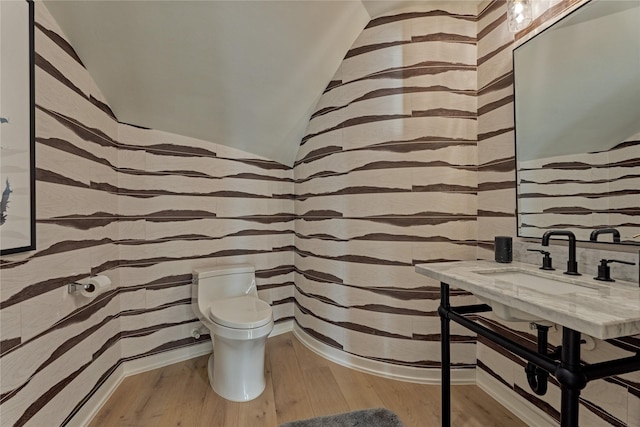 bathroom with wallpapered walls, wood finished floors, and toilet