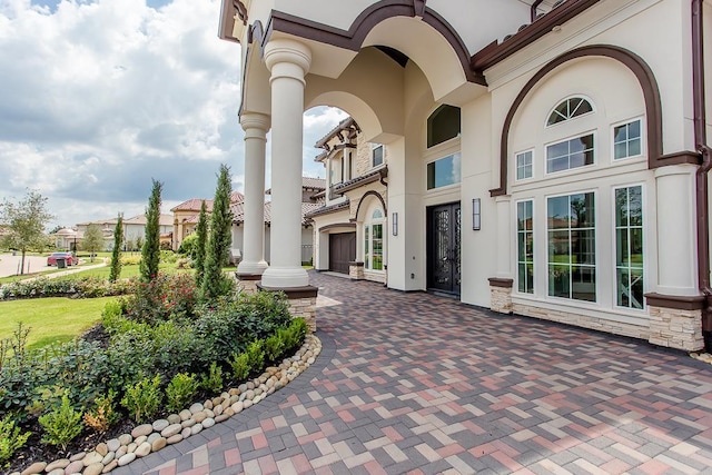 property entrance with stone siding and stucco siding