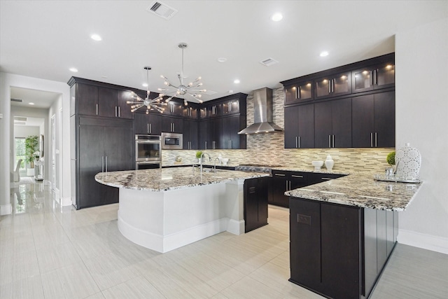 kitchen featuring stainless steel appliances, tasteful backsplash, wall chimney exhaust hood, visible vents, and baseboards