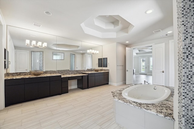 bathroom featuring visible vents, a raised ceiling, a whirlpool tub, and recessed lighting