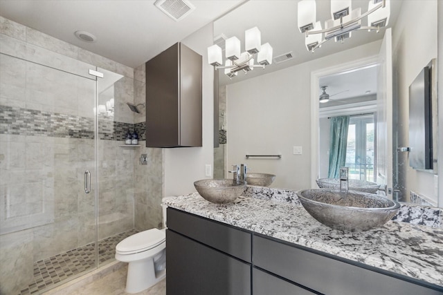 full bathroom featuring toilet, visible vents, a shower stall, and a sink