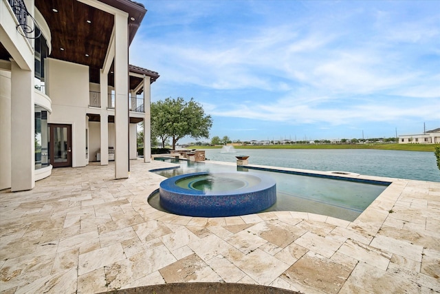 view of pool with a patio, a pool with connected hot tub, and a water view