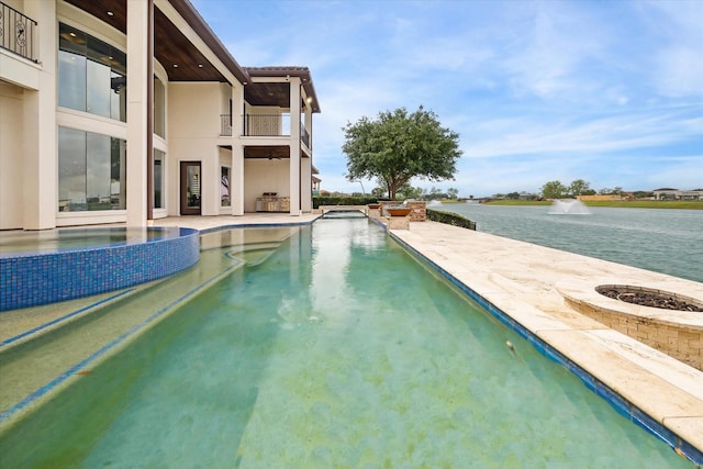 view of pool featuring a water view, a pool with connected hot tub, and a patio area