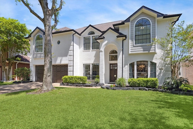 view of front of house with brick siding, an attached garage, a front yard, and driveway