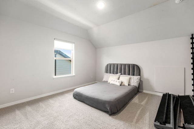 carpeted bedroom featuring lofted ceiling and baseboards