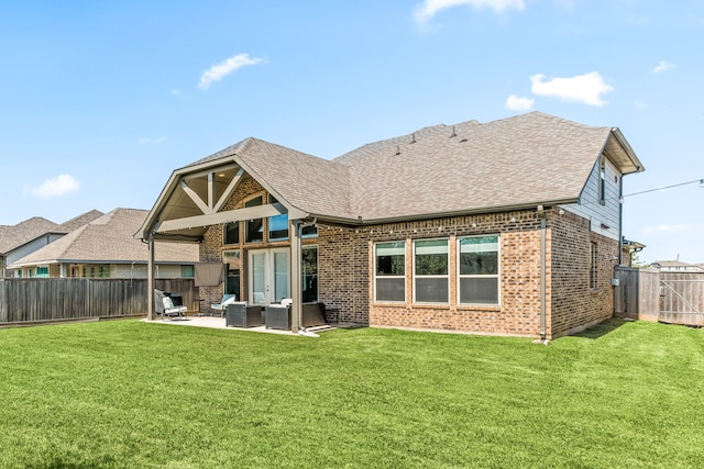 back of house with outdoor lounge area, a fenced backyard, a patio area, a lawn, and brick siding
