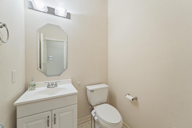 bathroom featuring vanity, toilet, and baseboards
