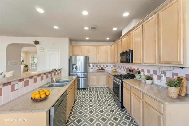 kitchen with appliances with stainless steel finishes, a sink, light brown cabinets, and recessed lighting
