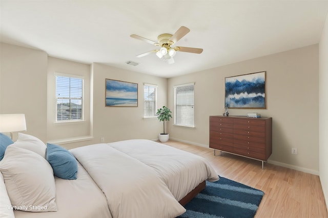 bedroom featuring light wood finished floors, baseboards, and ceiling fan
