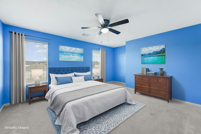 bedroom featuring multiple windows, carpet flooring, a ceiling fan, and baseboards