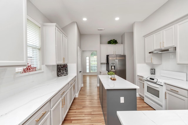 kitchen with white electric range, light wood finished floors, under cabinet range hood, stainless steel fridge with ice dispenser, and backsplash
