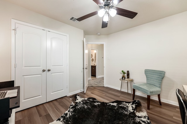 sitting room featuring ceiling fan, baseboards, wood finished floors, and visible vents