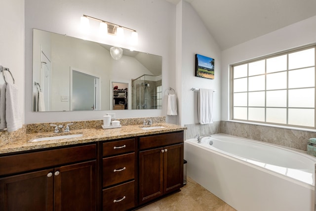 bathroom with a shower stall, vaulted ceiling, a garden tub, and a sink