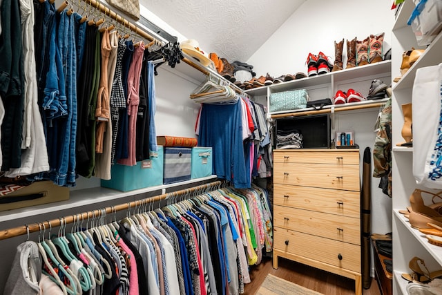 walk in closet featuring lofted ceiling and wood finished floors